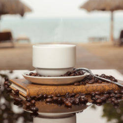 Kaffee in einer Tasse auf einem Tisch am Strand