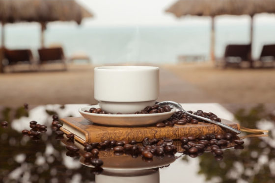 Kaffee in einer Tasse auf einem Tisch am Strand