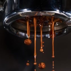 Espresso tropft aus bodenlosem Siebträger