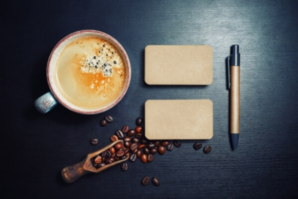 Kaffeetasse und Kaffeekirschen mit Stift und Block aus Vogelperspektive