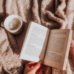 Kaffee Creme und ein Buch auf einer Decke